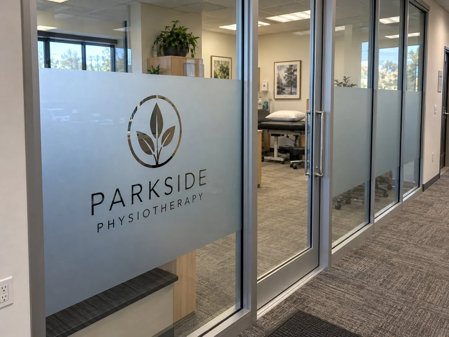 Frosted privacy film with a cut-out clinic logo on glass office partitions
